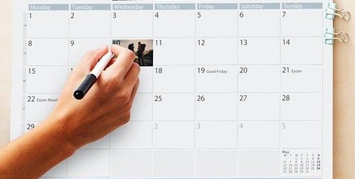 Ręka zapisująca notatkę na stronie kalendarza.